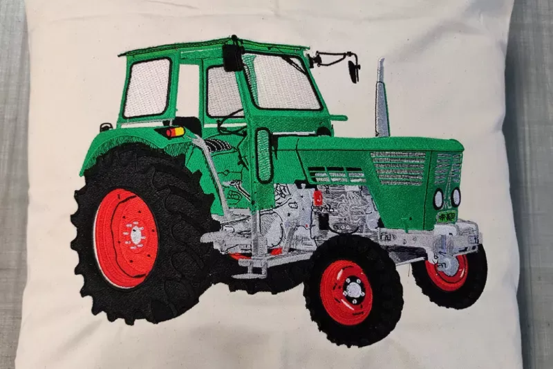Textilveredelung Stickerei Motiv Traktor Referenzen SICHTBAR Beschriftung Belp